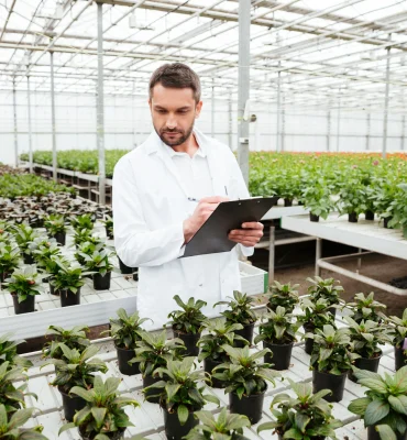 young-gardener-working-with-plants-greenhouse